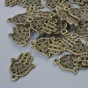 Fournitures pour pendentifs «Hamsa», diamètre 21×15 mm, diamètre du trou 1,7 mm, emballage 24 pièces ±, couleur bronze du métal