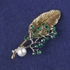 Broche-pendentif Brindille avec des cristaux verts, perle blanche, métal doré et argenté 76 × 33 mm et plus