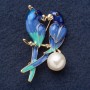Broche «Paire de perruches» 5,5 × 2 cm émail bleu clair, métal jaune