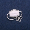 Broche‑pendent Masque, émail blanc et strass, métal argenté 37×41 mm