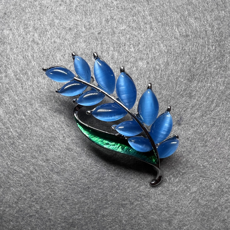Broche « Branche » œil-de-chat bleu, émail vert, métal doré 22×47 mm